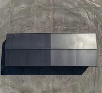 Entrepôt industriel préfabriqué en structure acier avec revêtement métallique foncé et entrée à pignon vitré