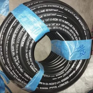 Chantier de construction avec câble industriel noir enroulé sur dalle de béton, machines lourdes, matériaux de construction - Product Image 1