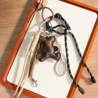 Petit porte-clés et pendentif pour sac ou téléphone, en alliage et matériaux mixtes, avec breloque ours en peluche en cuir et cordon tressé semi-artisanal, en forme de raquette de tennis