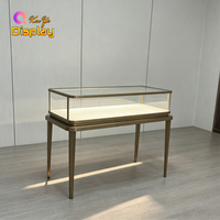 Vitrine de présentation de bijoux de luxe avec cadre en or brossé, verre trempé et éclairage LED pour boutiques, commerces de détail et centres commerciaux