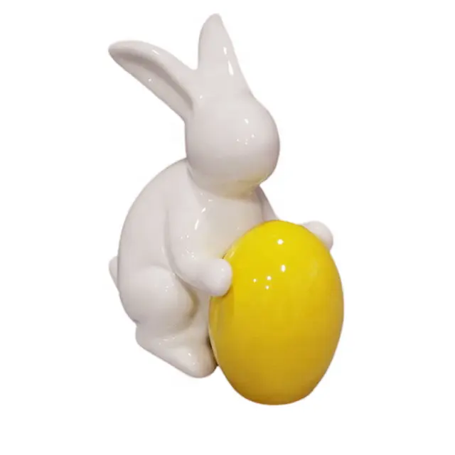 2021 Pascua primavera Decoración de casa de cerámica conejo blanco conejo con amarillo huevo en la mano