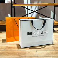 Sacs en papier cartonnés de luxe personnalisés avec logo imprimé pour la promotion de vêtements, cadeaux et achats en gros, avec poignées longues pour chaussures