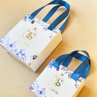 Boîte cadeau de luxe blanche pour bijoux, personnalisée avec estampage à chaud doré et ruban satiné, idéale pour les bijouteries.