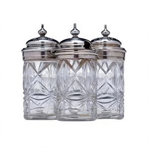Frasco de vidrio premium con tapa plateada y asa de metal dorado. Elegante contenedor de almacenamiento de vidrio transparente con detalles de lujo en plata y oro. - Product Image 1