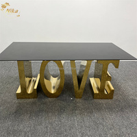 Table de salle à manger NIKA de luxe avec lettres dorées brillantes LOVE, structure en acier inoxydable et plateau en verre, idéale pour les mariages, les événements et les fêtes