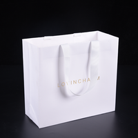 Sac en papier cadeau biodégradable et écologique en carton ivoire de luxe durable avec poignée en ruban, conception de logo personnalisée