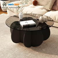Table basse ronde moderne avec plateau en verre et base en pétales noirs pour salon