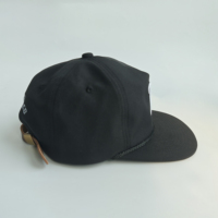 Casquette snapback noire en cuir avec étiquette latérale tissée et broderie 3D personnalisée pour hommes, style urbain, skateboard, hip-hop, usage quotidien et mode.
