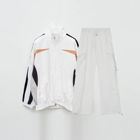 Ensemble survêtement streetwear pour homme : veste coupe-vent en nylon personnalisée avec logo brodé et patchwork, et pantalon baggy