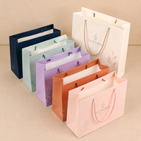 Sac en papier de luxe haut de gamme pour le commerce de détail, en papier artisanal, gaufrage, pelliculage mat, dorure à chaud, revêtement UV, recyclable, pour cadeaux de mode et bougies