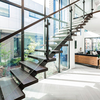 Escalier mono-poutre pour petit appartement avec poutre en acier mince et main courante minimaliste