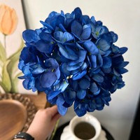 Arrangements floraux de mariage aux tons bleu Klein, bleu saphir profond, bleu royal, roses en soie, pivoines, centres de table hauts pour plafonds.