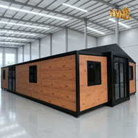 Maison conteneur extensible à effet bois avec structure en acier noir, maison mobile préfabriquée moderne pour habitation et bureau