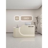 Comptoir de réception simple en MDF rectangulaire arrondi pour magasin de vêtements, salon de beauté, studio de yoga, design style crème, finition cuite