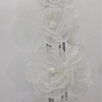 Arrangements floraux géants en organza blanc sur mesure, luxueux et haut de gamme, pour décorations de mariage et vitrines.