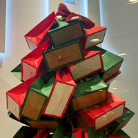 Sacs en papier kraft empilés de manière créative en forme de sapin de Noël, ajoutant une touche festive à l'affichage des magasins de vêtements
