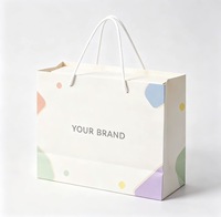 Sac cadeau en papier crème personnalisé avec imprimé géométrique coloré, poignée en corde de coton, logo de marque personnalisé pour l'emballage de vente au détail en boutique