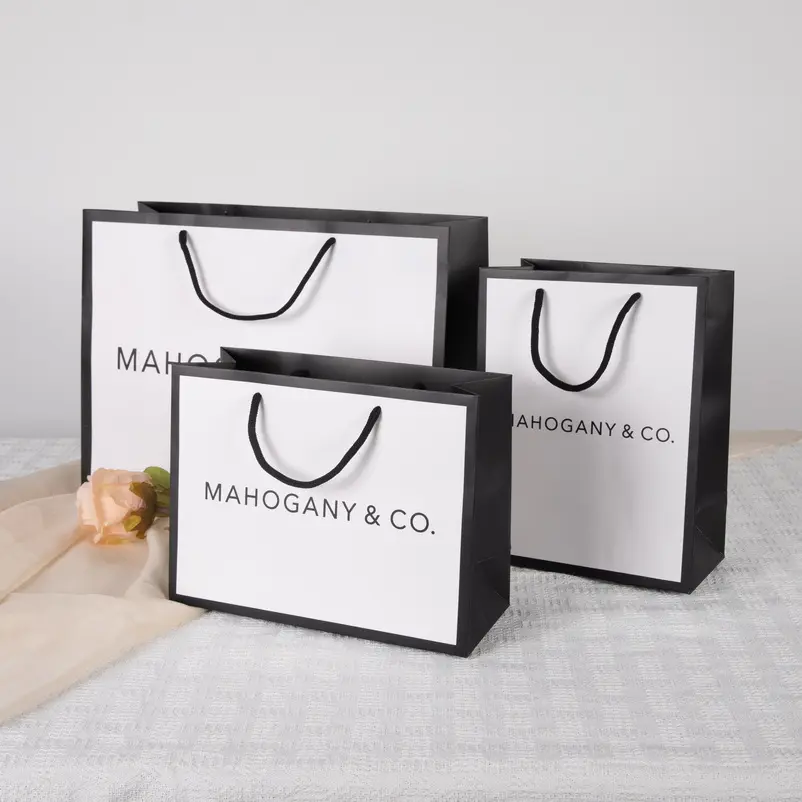 Impresión personalizada de su propio logotipo boutique ropa embalaje bolsa de papel eco blanco ropa compras regalo bolsas de papel con asa de cinta