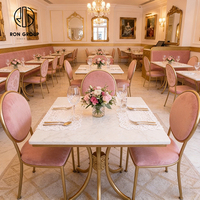 Elegante Franse roze fluwelen bankzittingen met gouden frame, tafel en stoelen van gesinterd steen, meubelset voor koffieshop en restaurant