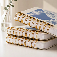 Carnet personnalisé avec couverture photo, finition crème mate, reliure spirale dorée, pages en carton épais, impression personnalisée de carnets à spirale.