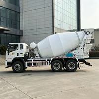 Camion malaxeur à béton avec cuve de mélange blanche et chute de déchargement arrière pour la livraison de béton prêt à l'emploi