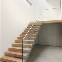 Escalier droit moderne en bois massif flottant avec structure en acier et garde-corps en verre transparent, design ouvert