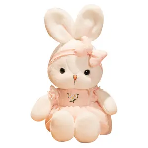 かわいい小さな白いウサギの人形はドレスを着ますウサギは枕を投げます子供の男の子と女の子の休日の誕生日プレゼント