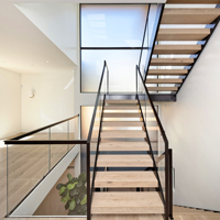 Balustrade en verre plat installée à côté d'une double poutre et de marches en bois antidérapantes