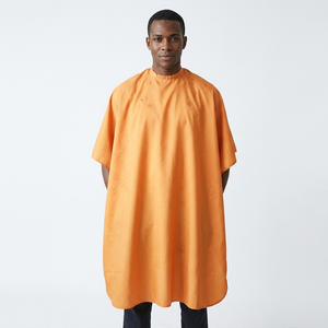 Cape de coiffure orange en textile anti-adhérent aux cheveux, antistatique, avec taille réglable en plastique - Product Image 1