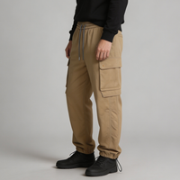 Celana Jogger Cargo Pria Warna Tan Khaki, Model Relaxed Tapered, Pinggang Elastis dengan Tali Serut, Kantong Bellows, Kantong Welt, Kantong Bungee, Grosir OEM