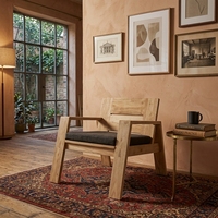 Fauteuil en teck de luxe avec revêtement moelleux et savoir-faire de qualité supérieure pour salons et salles de séjour élégants.