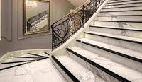 Escalier courbé classique avec des motifs en fer forgé sur mesure, marches en bois et en marbre