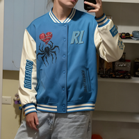 Blouson universitaire homme bleu crème colorblock avec motif cœur d'araignée et lettres brodées sur le devant et le dos, style streetwear vintage