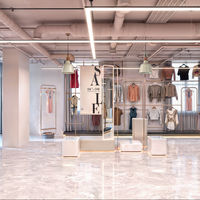 Tienda de ropa moderna Diseño de mostrador de piso lacado Estantes de pared personalizados Estantes de exhibición de ropa de acero inoxidable Góndola de madera