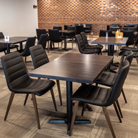 Ensemble table et chaises de restaurant moderne avec sièges rembourrés noirs et pieds en métal imitation bois pour café, bistrot, hôtel, salle à manger