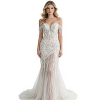 Tissu en dentelle de haute couture lourdement perlé avec franges en boucle motif feuille d'argent sur tulle ivoire pour robe de mariée et robe de soirée