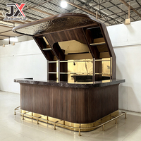 Comptoir de bar incurvé sur mesure de qualité supérieure, panneau en bois de noyer cannelé, dessus en marbre foncé, repose-pieds en laiton, éclairage LED, mobilier pour club et restaurant
