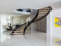 Escalier courbé avec rampes en acier inoxydable revêtu de noir et marches en bois massif, pour usage intérieur, design contemporain durable