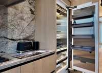 Meuble de cuisine moderne de luxe en bois clair sur mesure avec porte à panneau plat, îlot cascade en marbre et crédence pour villa