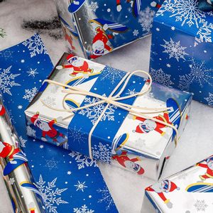 Papier d'emballage en aluminium imprimé flocons de neige et Père Noël skitant, bleu argenté, mignon, double face, pour emballer des cadeaux - Product Image 1