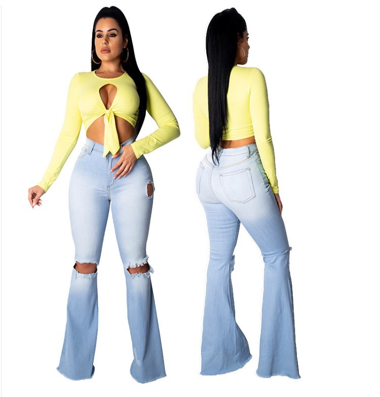 Pantalones vaqueros acampanados azul claro desgastados con roturas.