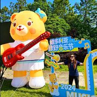 Modèle gonflable géant personnalisé d'ours mignon avec guitare pour la décoration d'événements de fête et de festivals de musique, durable et résistant à l'eau