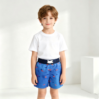 Short de bain Magic Water Reveal Boys Board Short bleu uni avec broderie requin et cordon de serrage blanc réglable pour les vacances d'été à la mer