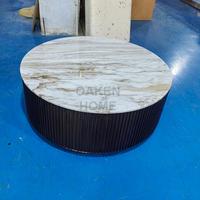 Table basse Finnley de style Arhaus personnalisable OAKEN, base en bois noir cannelé avec garniture en métal laiton, plateau rond en marbre