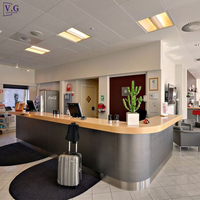Comptoir de réception en pierre jaune personnalisée avec bar en acier inoxydable en forme de L pour hôtel