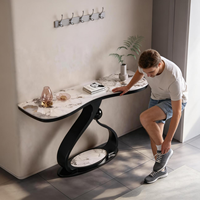 Table console de luxe pour salon et entrée, avec plateau en pierre courbé artistique haut de gamme et base sculpturale en métal noir
