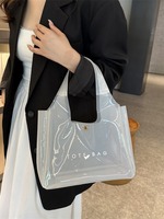 Sac de plage et de voyage transparent en PVC imperméable, petit format, avec logo personnalisé, motif lettres orange et violet, idéal pour le shopping ou comme cadeau.