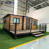 ZYBOX Cabina Prefabbricata Container da 20 piedi con Tetto Mono-Pitch, Finitura in Legno Naturale, Ampio Terrazza e Ringhiera in Ferro - Glamping Studio Pod