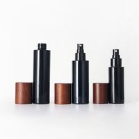 Nuevo frasco de vidrio redondo oscuro con tapa de abeto y dosificador, con bomba para loción, serigrafía y logotipo personalizado, para set cosmético y cuidado de la piel.