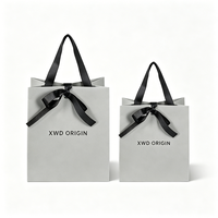Terima pesanan OEM ODM, tas kertas kado dengan permukaan glossy, struktur pita terintegrasi, cetak custom dalam jumlah kecil.